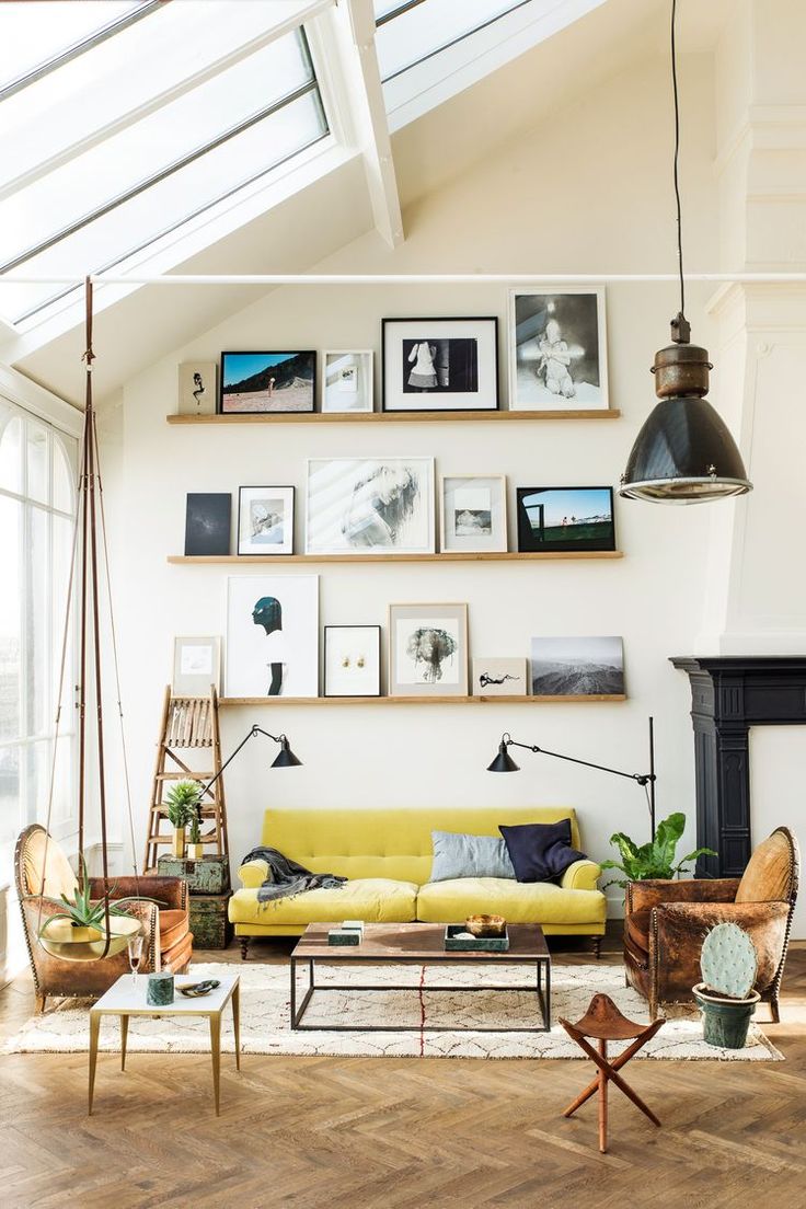 High ceiling living room with yellow count and pictures on ledge