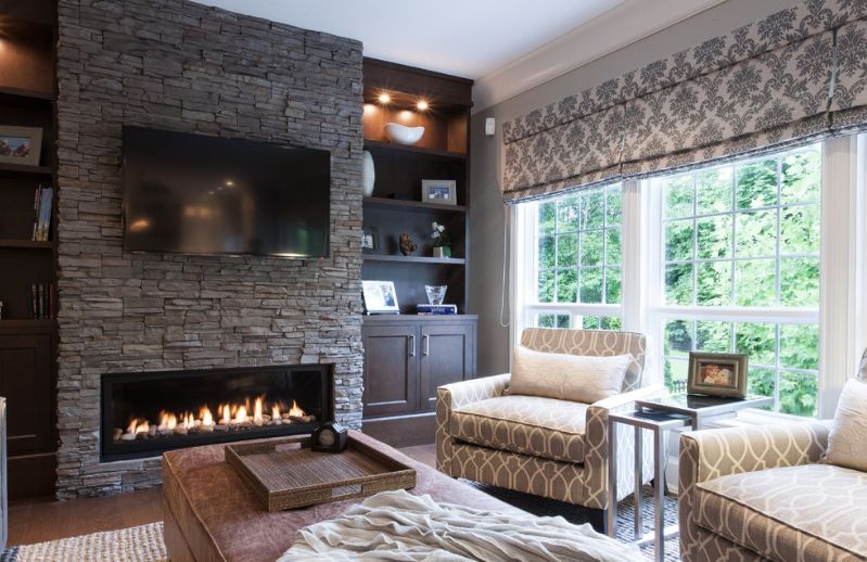 Grey stacked stone fireplace with tv above