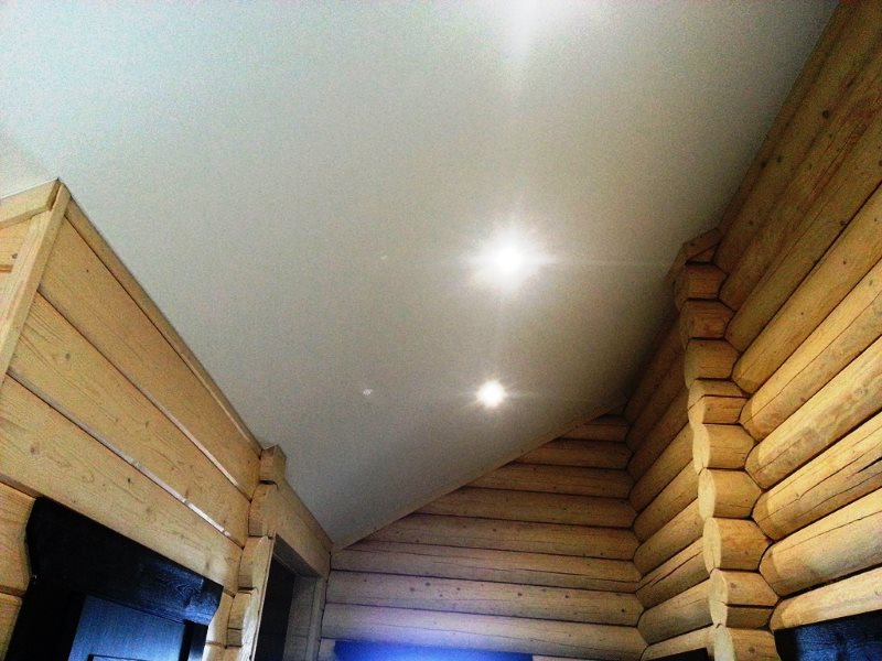 Ровная поверхность потолка из гипсокартона в доме из бревен