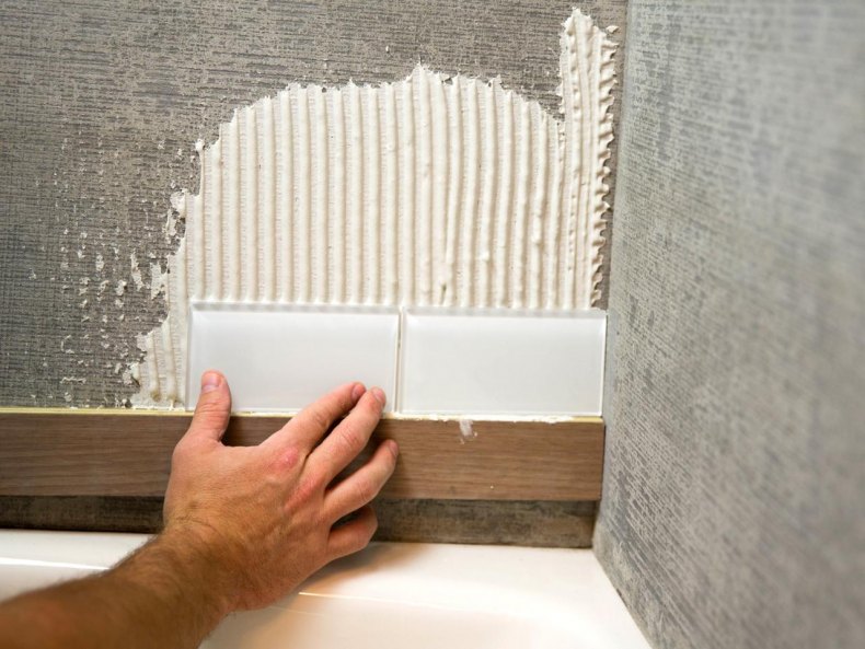  класть панели на стену:  крепить пластиковые панели к стене .